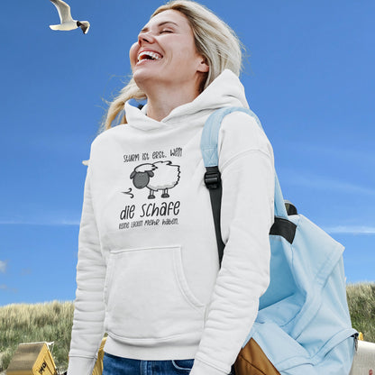 Frau im Hoodie Schaf am Strand